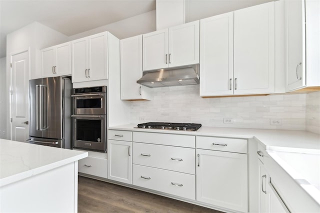 kitchen with white cabinets, appliances with stainless steel finishes, and decorative backsplash