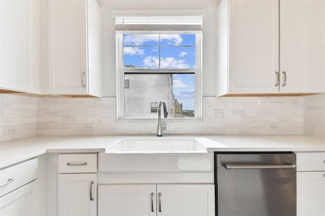 kitchen with tasteful backsplash, white cabinetry, sink, and stainless steel dishwasher