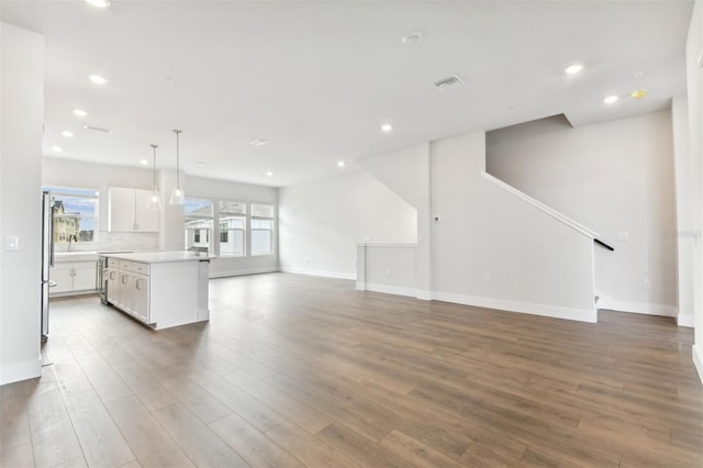 unfurnished living room featuring sink and dark hardwood / wood-style floors