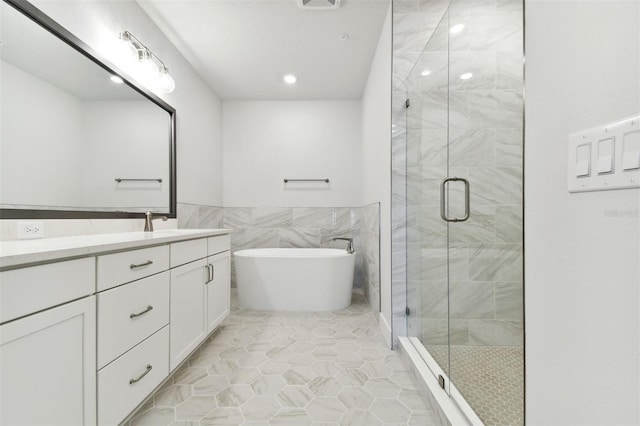 bathroom featuring separate shower and tub, tile patterned flooring, vanity, and tile walls