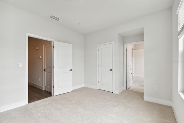 unfurnished bedroom with carpet flooring and ensuite bath