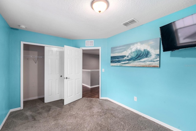 unfurnished bedroom with a closet, carpet floors, and a textured ceiling