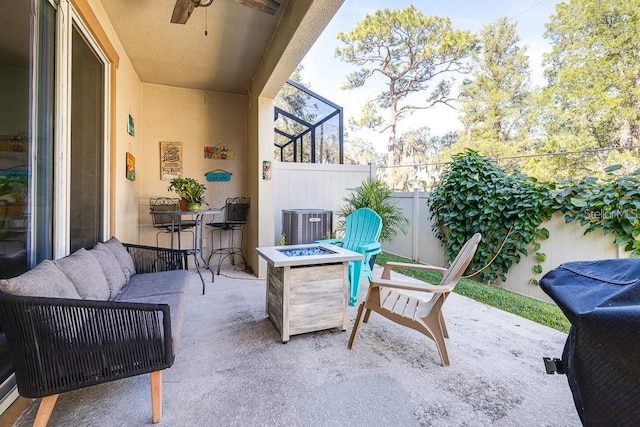 view of patio / terrace with cooling unit and an outdoor living space with a fire pit