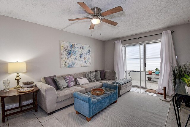 living room with ceiling fan and a textured ceiling