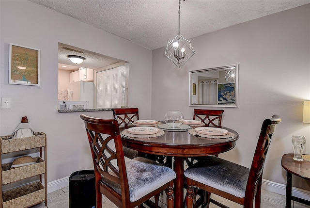 dining space with a textured ceiling and light tile patterned floors