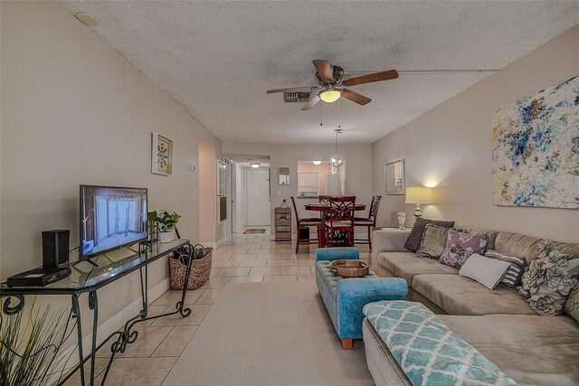 tiled living room with a textured ceiling and ceiling fan