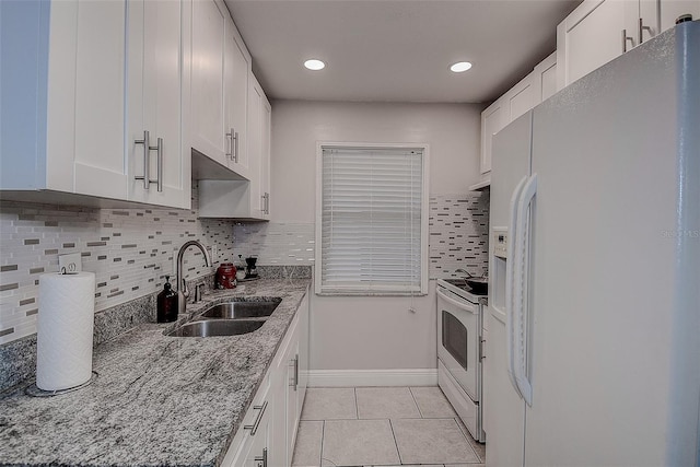 kitchen featuring sink, white appliances, tasteful backsplash, light stone countertops, and white cabinets