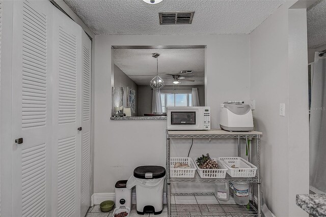 bathroom featuring a textured ceiling, ceiling fan, and tile patterned floors