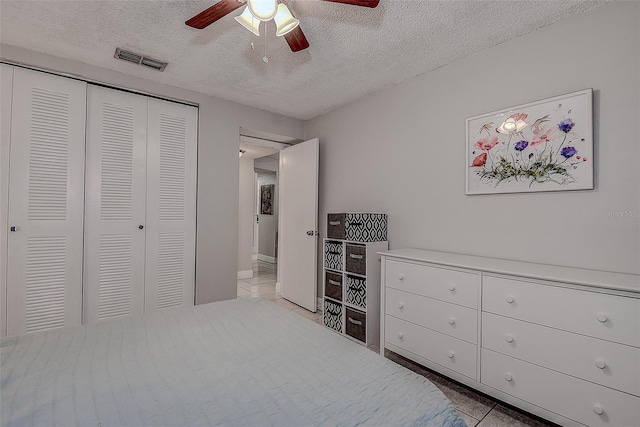 bedroom featuring ceiling fan, a closet, and a textured ceiling