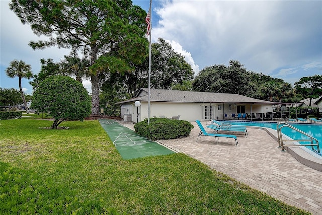 view of swimming pool featuring a patio and a yard