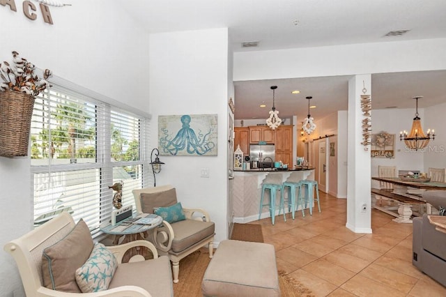 living room with sink, light tile patterned flooring, and a chandelier