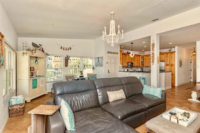 living room with a textured ceiling, light tile patterned flooring, and an inviting chandelier