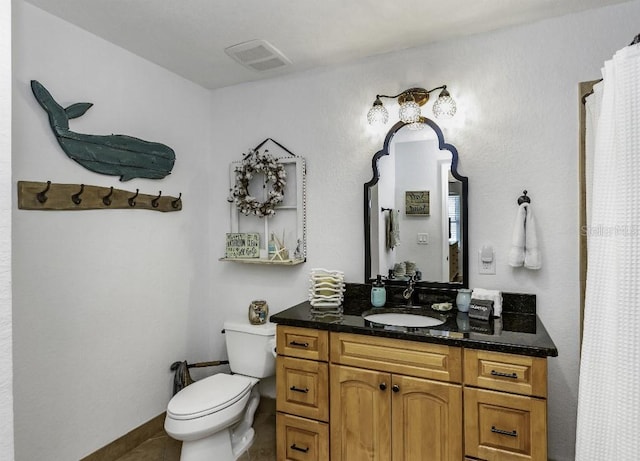 bathroom with toilet, vanity, and tile patterned floors