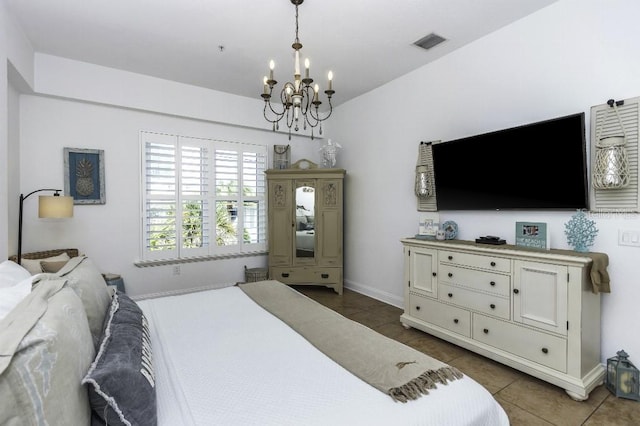 bedroom with dark tile patterned floors and an inviting chandelier