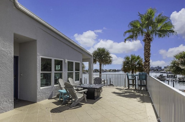 view of patio featuring a water view and a fire pit