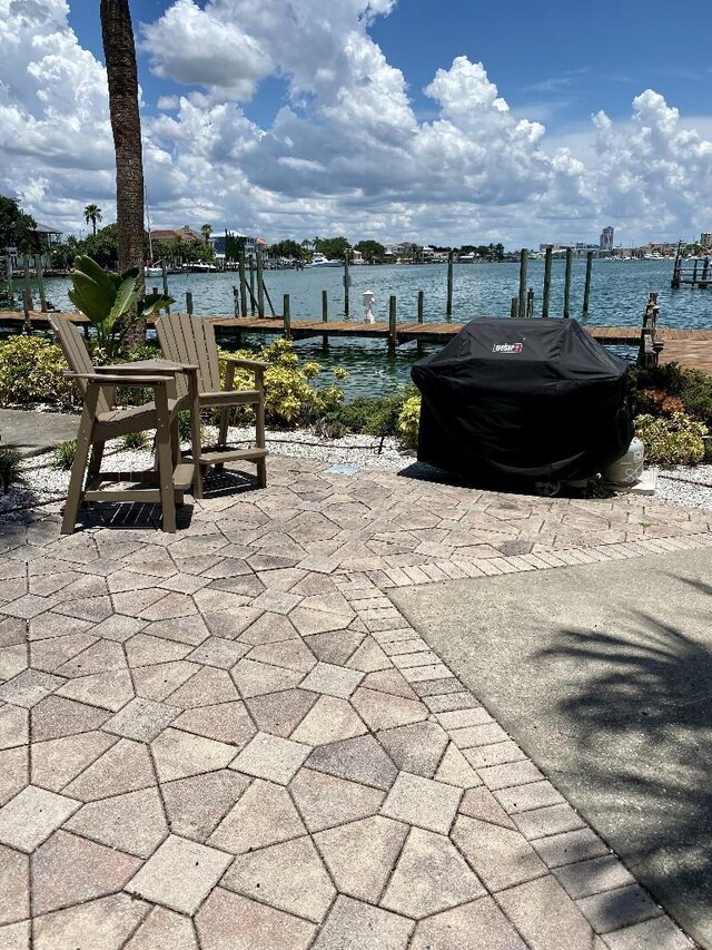 view of patio with a water view and a boat dock