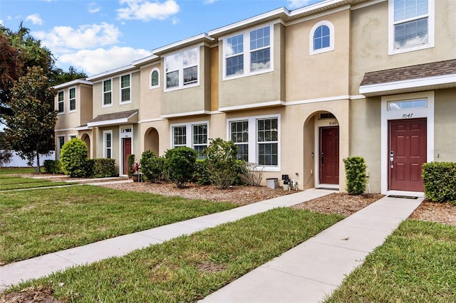 townhome / multi-family property featuring a front lawn