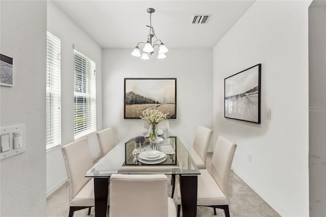 dining space featuring carpet and an inviting chandelier