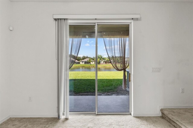 doorway to outside featuring a water view and carpet floors