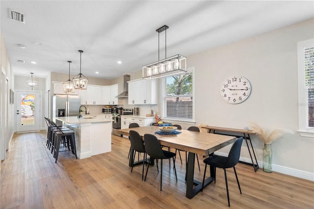 dining area featuring light wood-type flooring, plenty of natural light, and sink