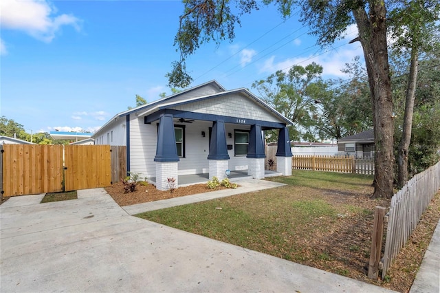 bungalow-style home featuring covered porch and a front yard