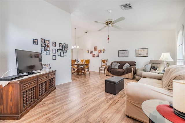 living room featuring ceiling fan, high vaulted ceiling, and light hardwood / wood-style flooring