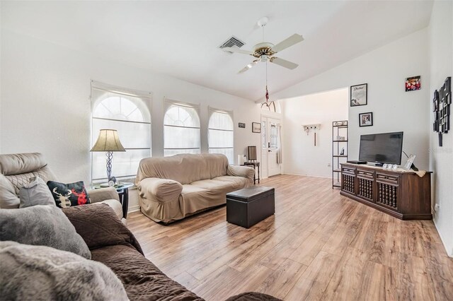 living room featuring ceiling fan, light hardwood / wood-style floors, and vaulted ceiling