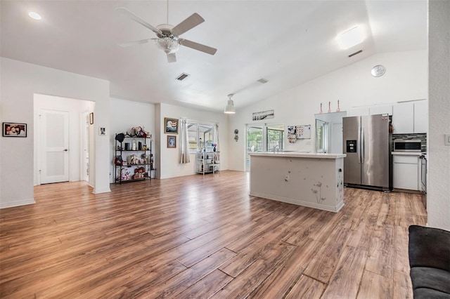 kitchen with ceiling fan, light wood-type flooring, white cabinets, a center island, and stainless steel appliances