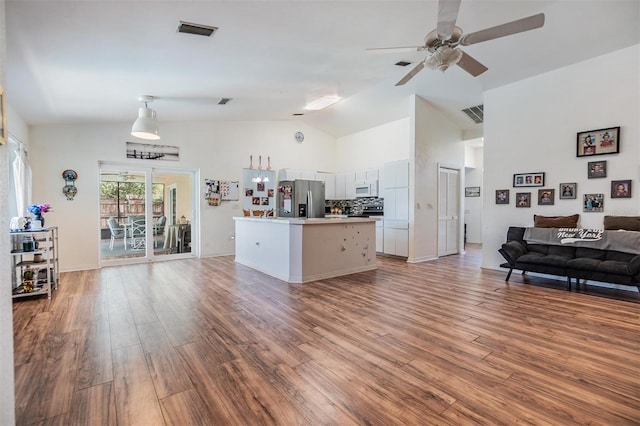 kitchen with hardwood / wood-style flooring, stainless steel fridge, backsplash, and a center island