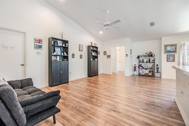 living room featuring light hardwood / wood-style floors, high vaulted ceiling, and ceiling fan