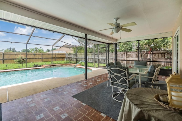 view of swimming pool with ceiling fan, glass enclosure, and a patio area