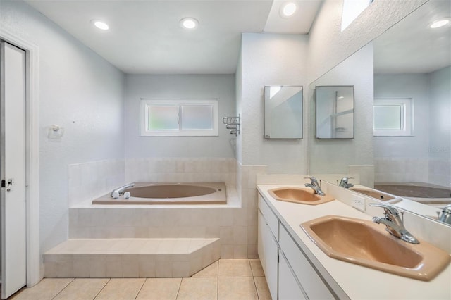 bathroom with tile patterned flooring, a relaxing tiled tub, and dual bowl vanity