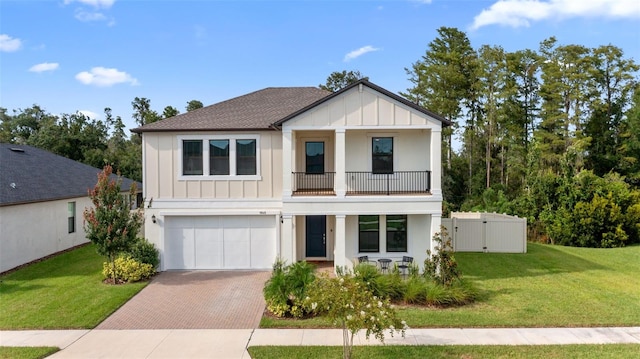 view of front of home featuring a balcony, a front yard, and a garage