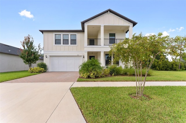 view of front of home with a balcony, a garage, and a front lawn