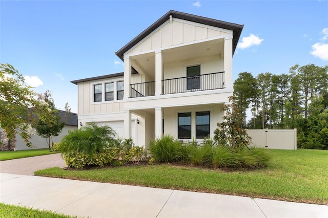 view of front of home featuring a balcony and a front yard