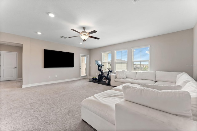 carpeted living room with ceiling fan