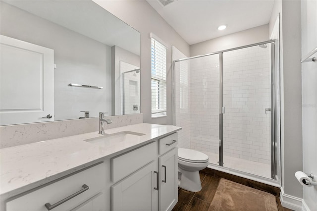 bathroom with walk in shower, toilet, vanity, and wood-type flooring