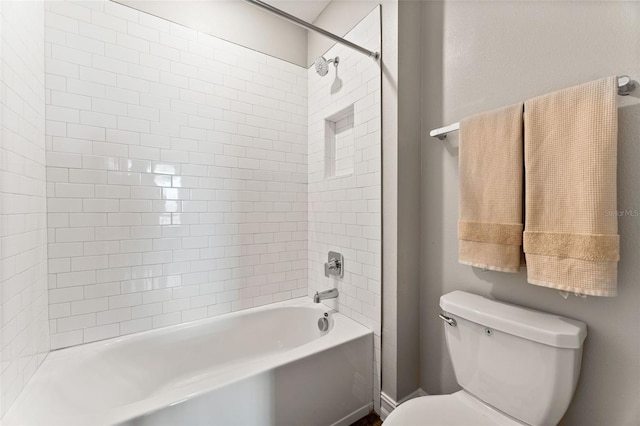 bathroom featuring tiled shower / bath and toilet