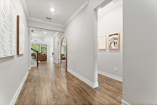 corridor with wood-type flooring and ornamental molding