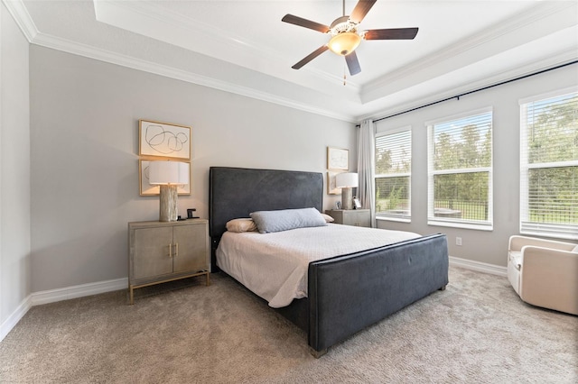 carpeted bedroom featuring ceiling fan, a tray ceiling, and ornamental molding