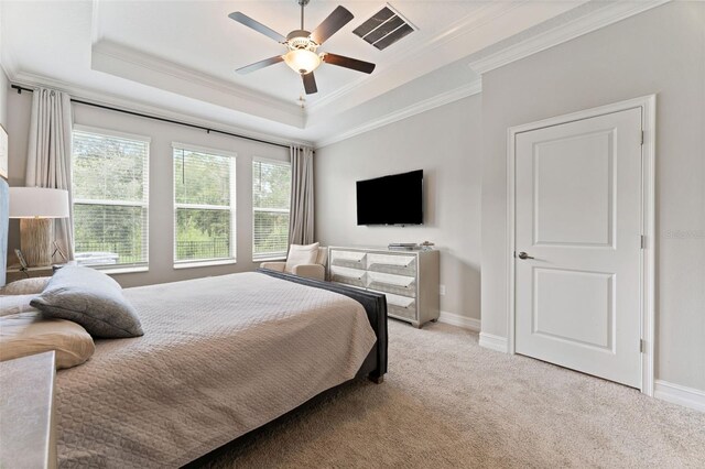 bedroom featuring light carpet, a tray ceiling, and ornamental molding