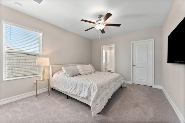 bedroom featuring connected bathroom, ceiling fan, and light carpet