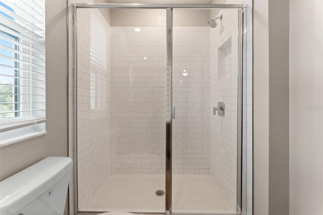 bathroom featuring an enclosed shower and toilet