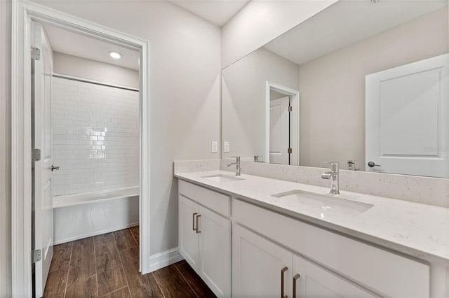 bathroom with vanity, tiled shower / bath, and hardwood / wood-style floors