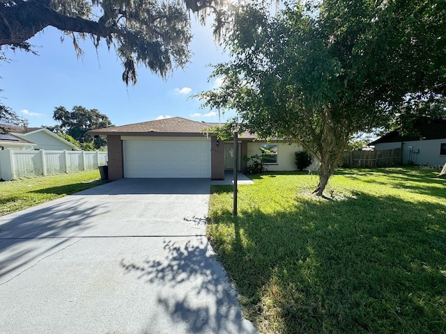 ranch-style house with brick siding, concrete driveway, an attached garage, a front yard, and fence