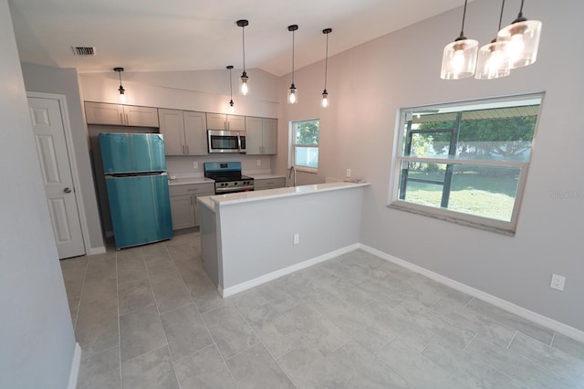 kitchen with appliances with stainless steel finishes, a peninsula, hanging light fixtures, gray cabinets, and light countertops