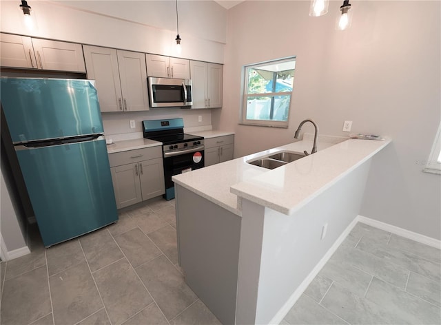 kitchen with stainless steel appliances, a sink, a peninsula, and gray cabinetry