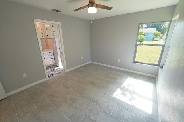 spare room with baseboards, visible vents, and a ceiling fan