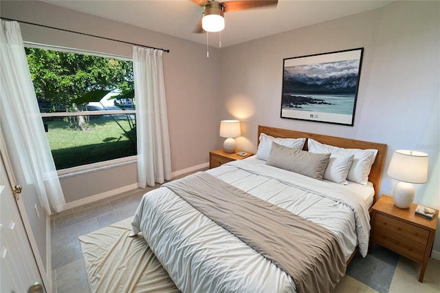 bedroom featuring light tile patterned floors, baseboards, and a ceiling fan