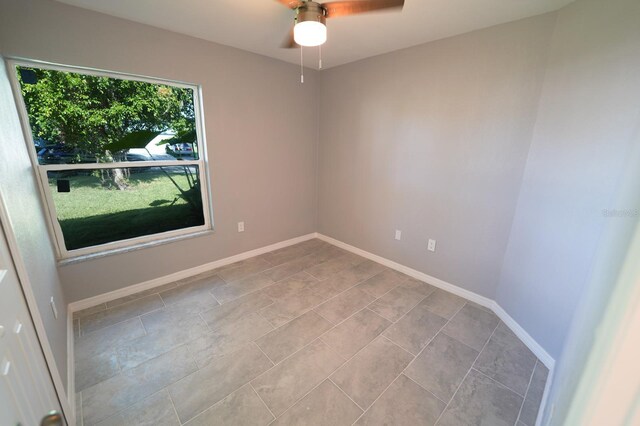 unfurnished room with baseboards and a ceiling fan